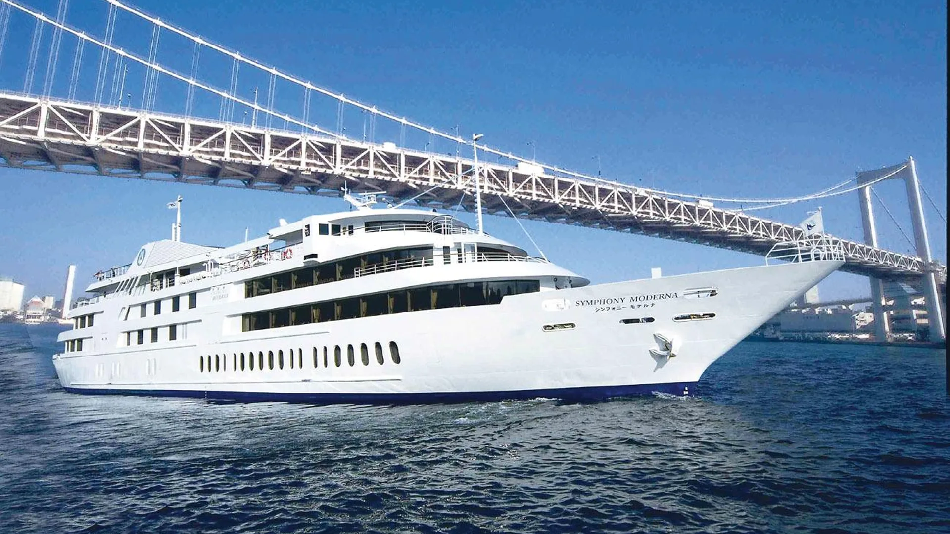A white cruise boat on Tokyo Bay passing under the Rainbow Bridge, from the Hato Bus day tour listing